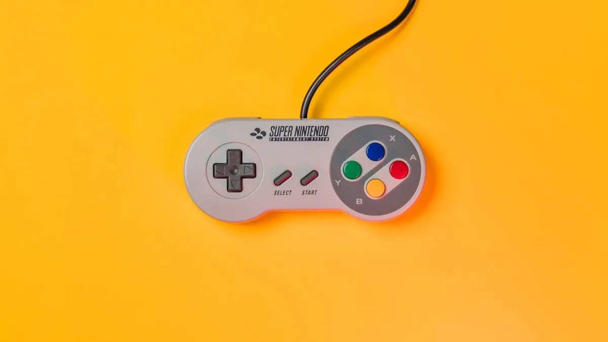 white nintendo game controller on yellow surface