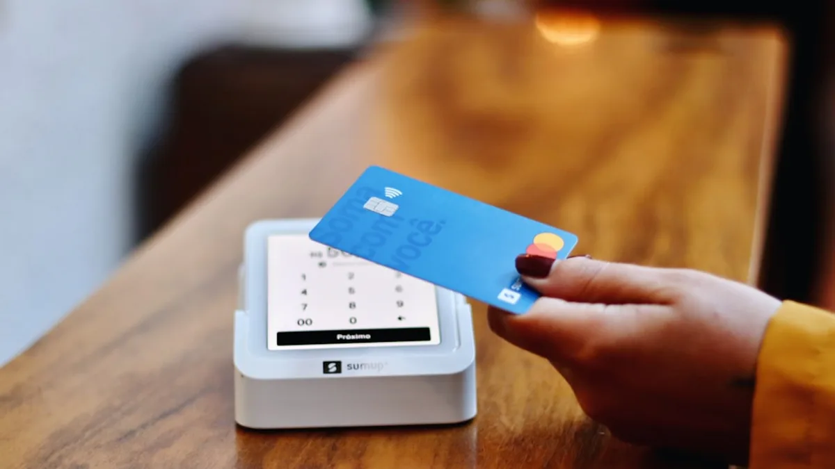 a person holding a credit card in front of a machine