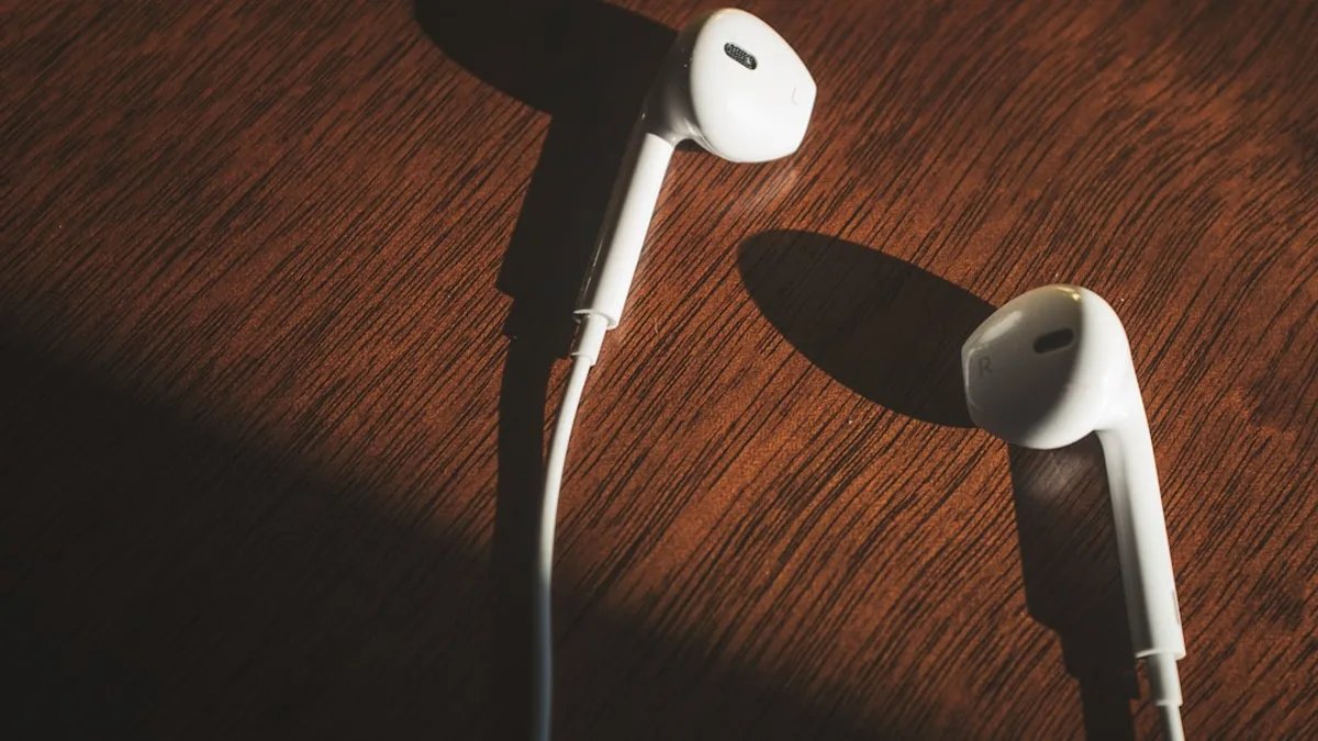white earbuds on brown wooden table