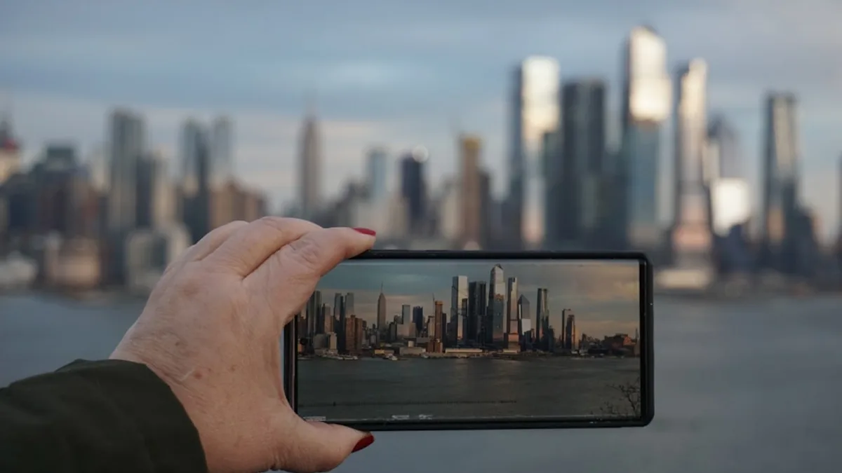 A person taking a picture of a city with a cell phone