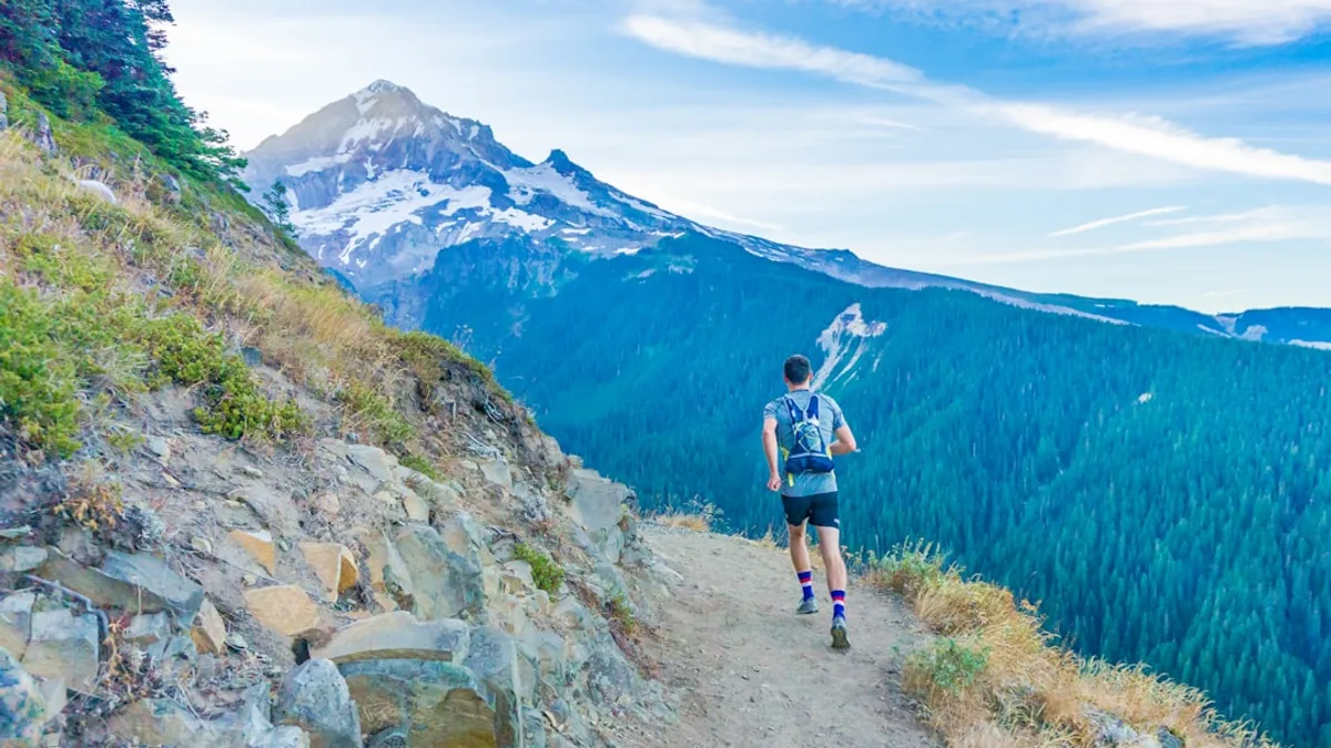 man running on edge near mountain
