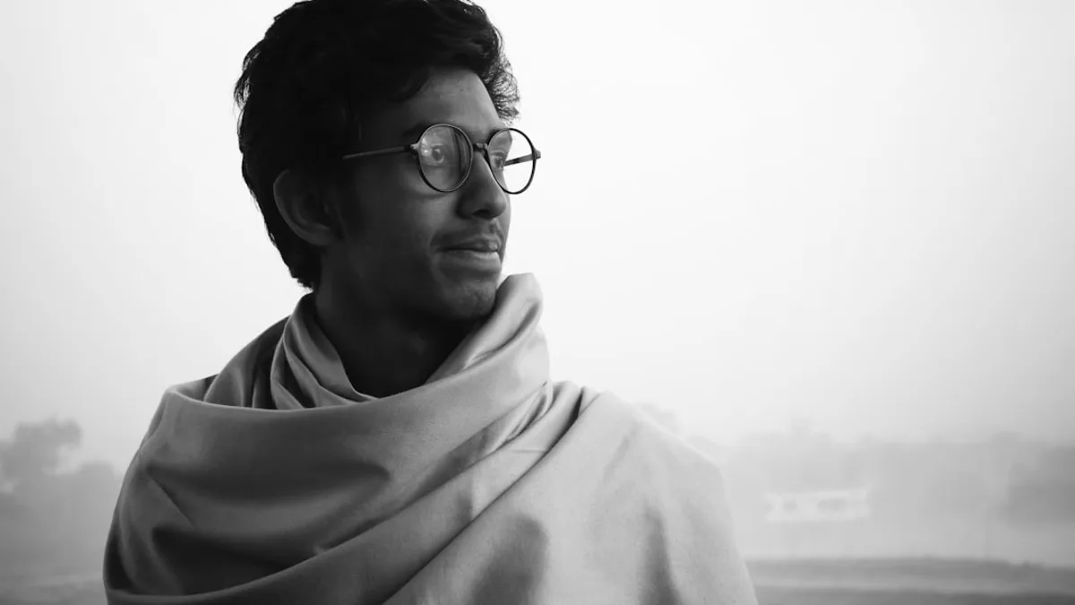 a man wearing glasses and a shawl