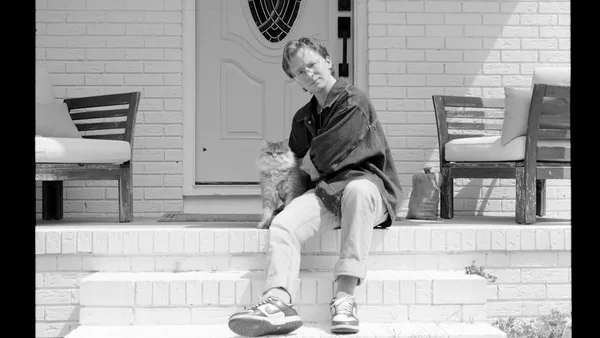 Man and cat sitting on porch steps