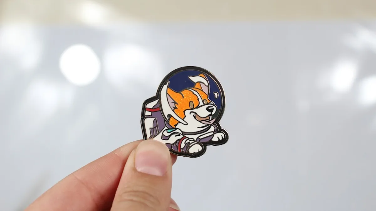 Hand holding a small cartoon cat pin