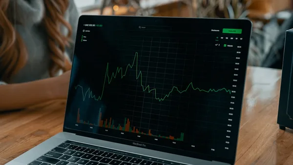 laptop showing stock chart on desk
