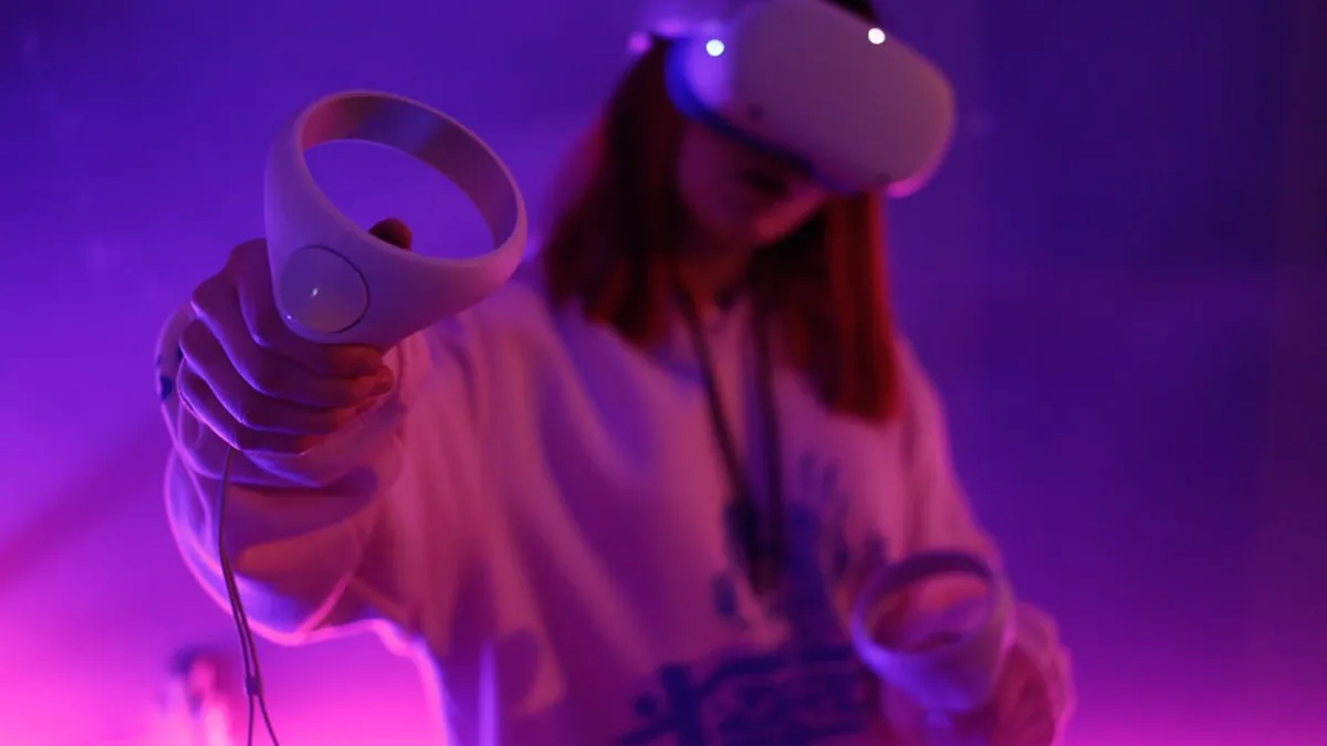a woman holding a video game controller in her hand