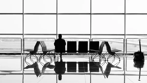 man sitting on gang chair during daytime