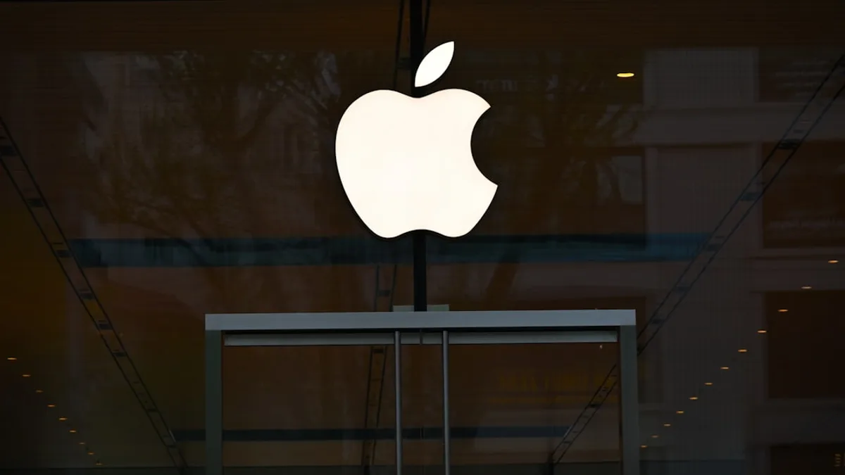 the apple logo is reflected in the glass of a building