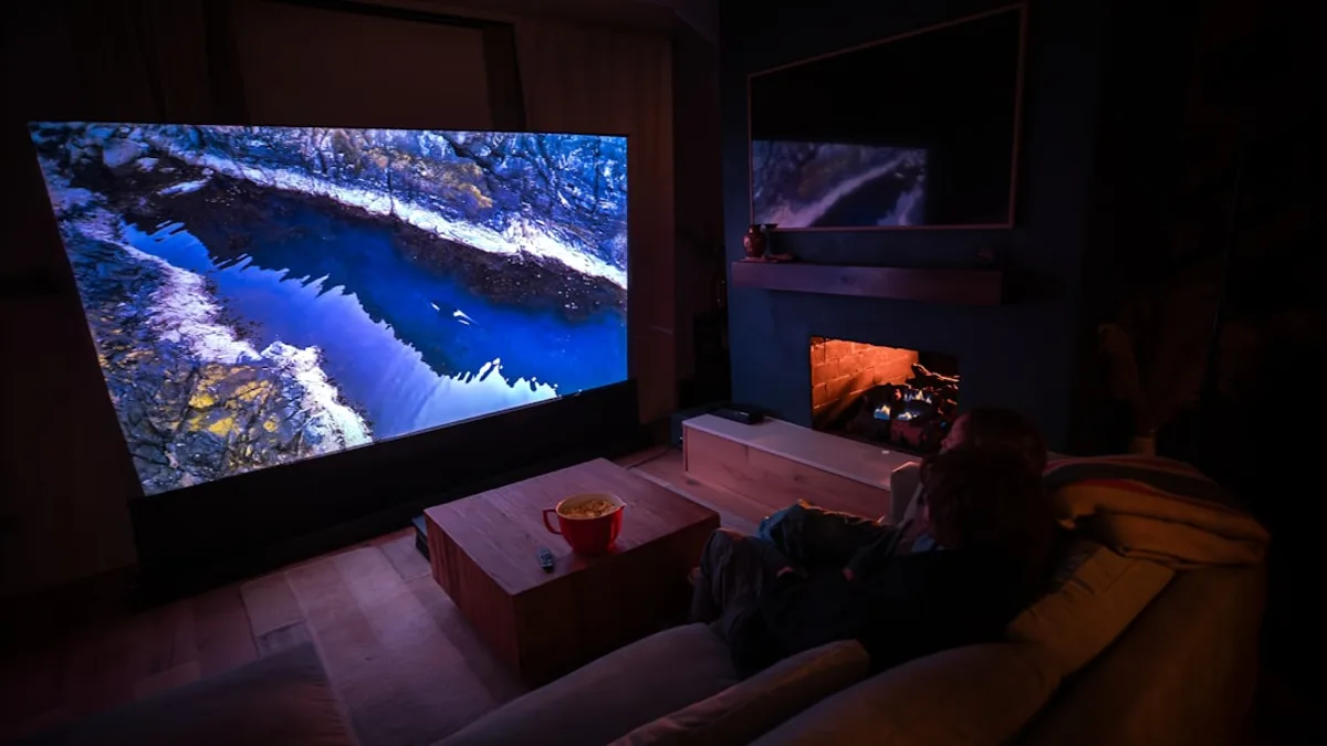 A person sitting on a couch in front of a flat screen TV