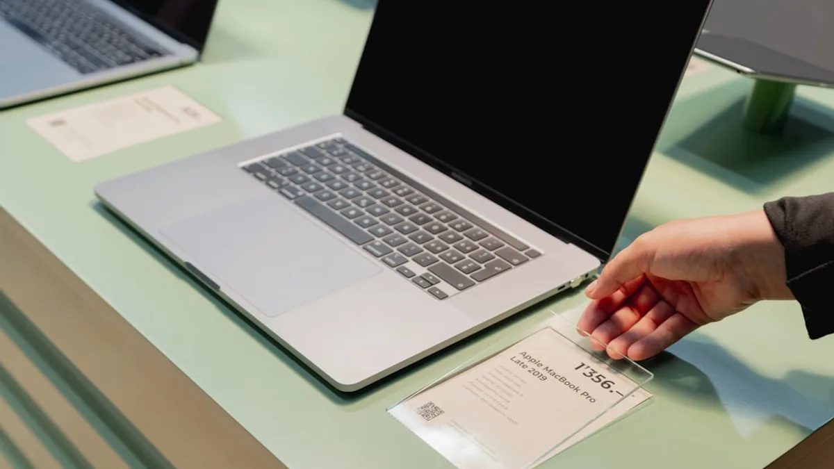 a person's hand on top of a laptop computer