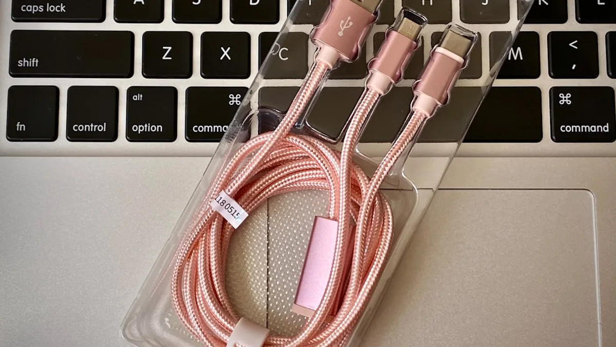 a couple of pink cables sitting on top of a laptop