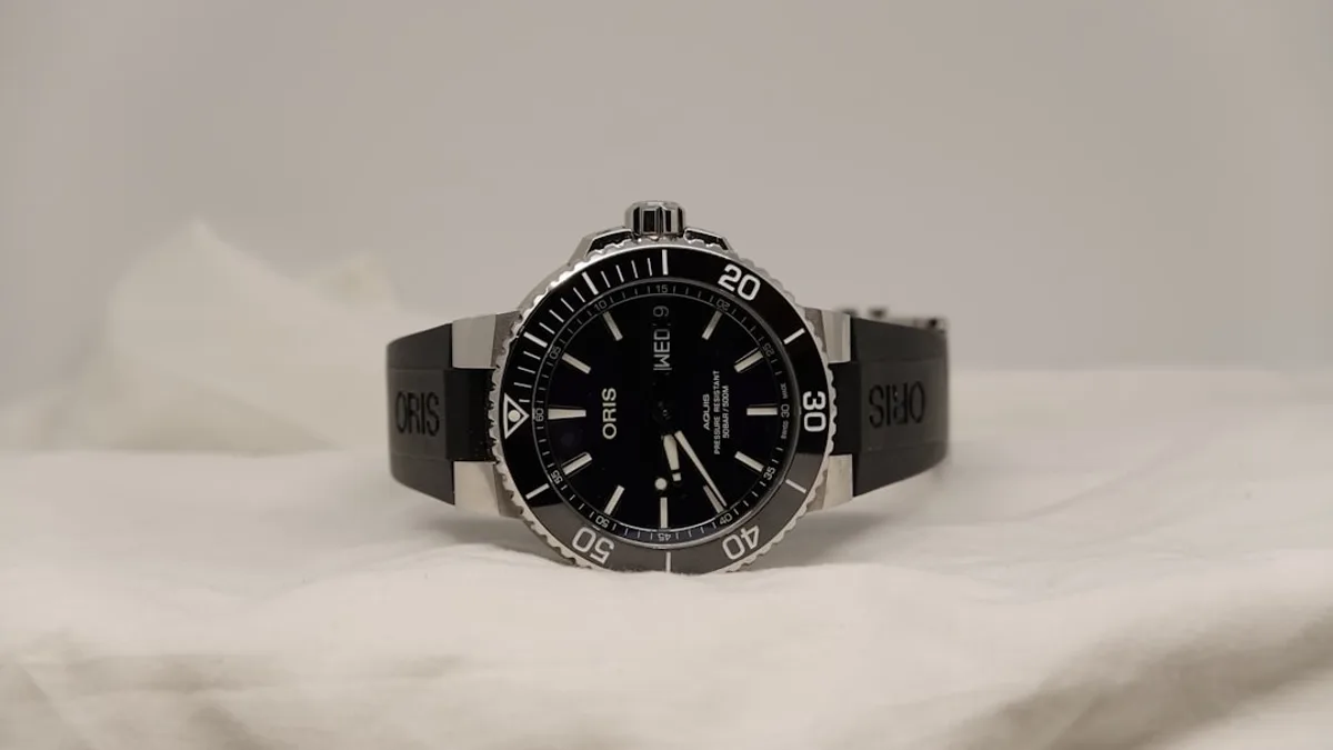 a watch sitting on top of a white sheet
