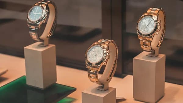 three round silver-colored chronograph watches on white mounts