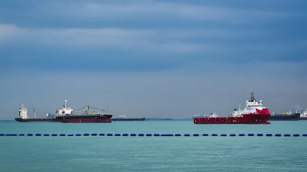 three large ships in the ocean with a sky background