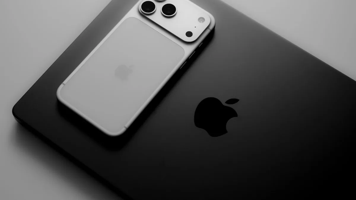 Silver smartphone resting on a black laptop.