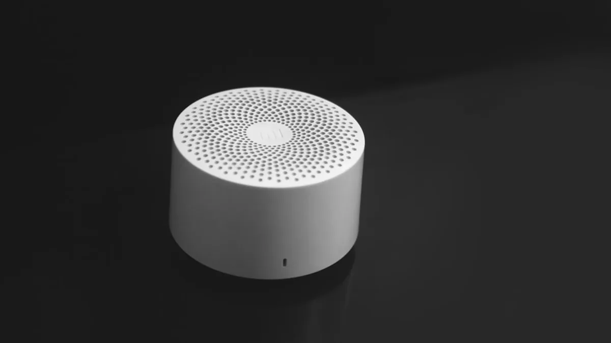 a white speaker sitting on top of a black table
