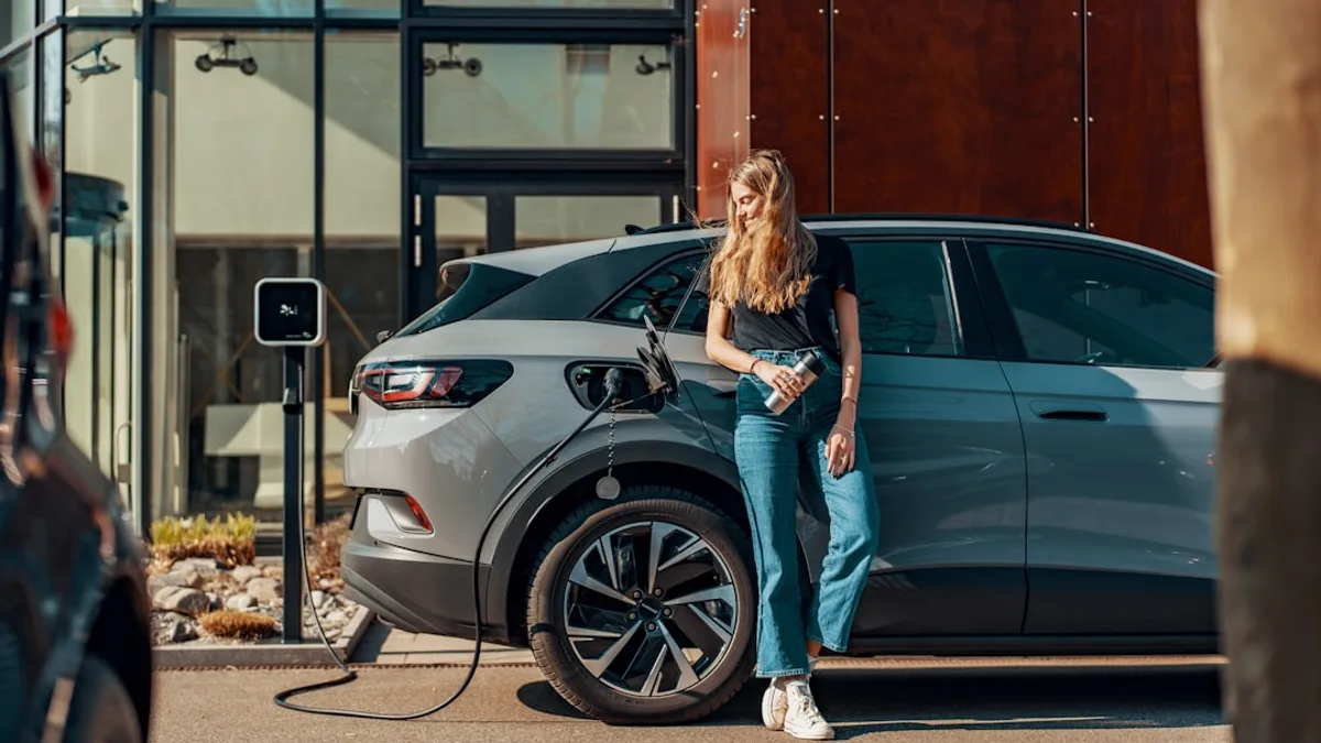 a woman standing next to a blue car