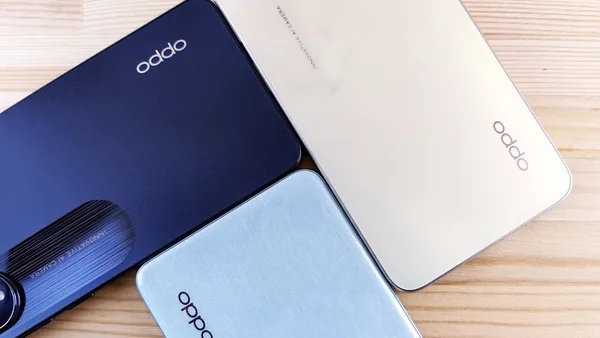 three oppo phones sitting on top of a wooden table