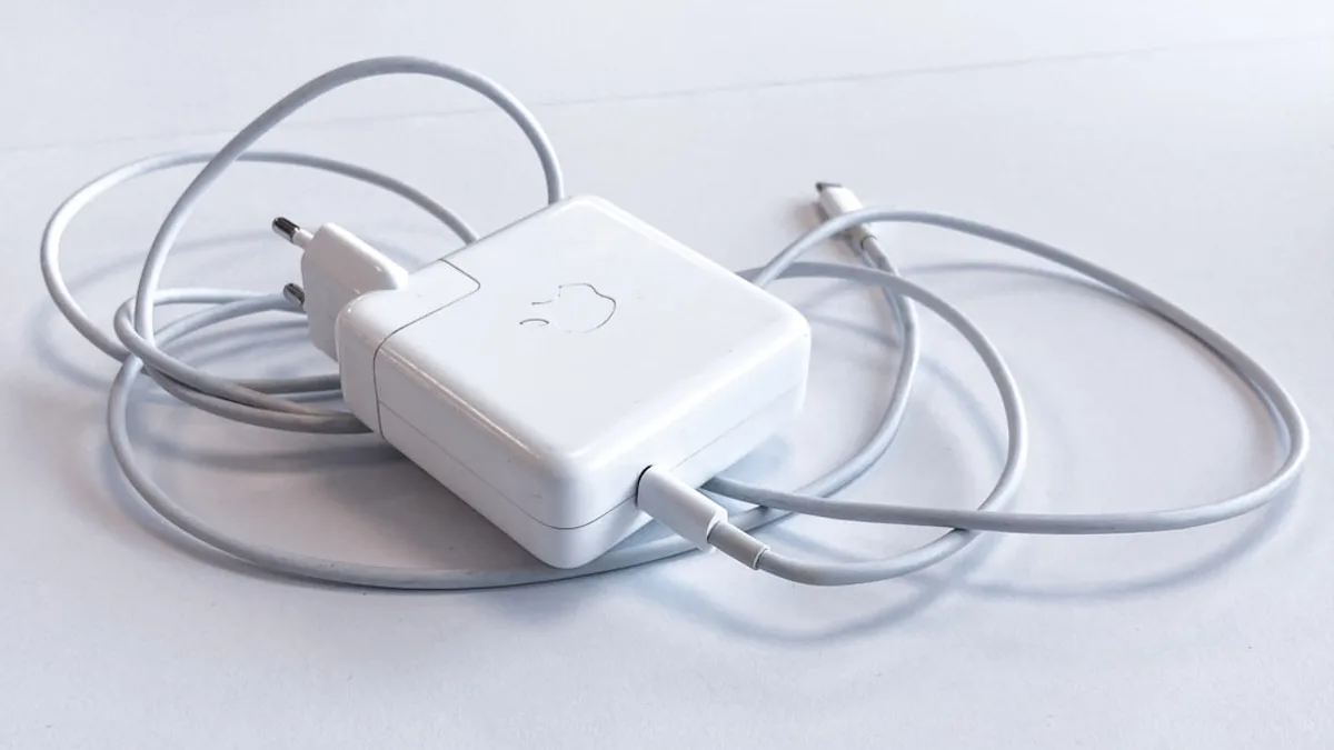 white apple charging adapter on white table