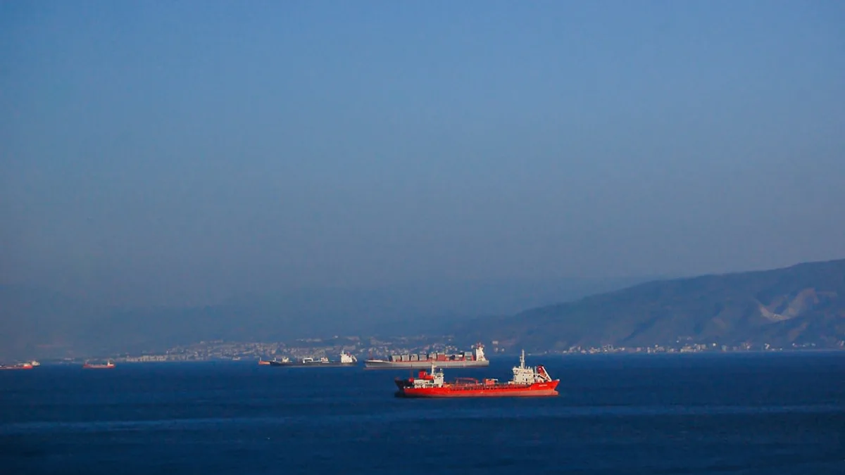 A large red boat floating on top of a large body of water