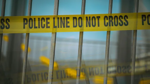 a close up of a yellow police line behind bars