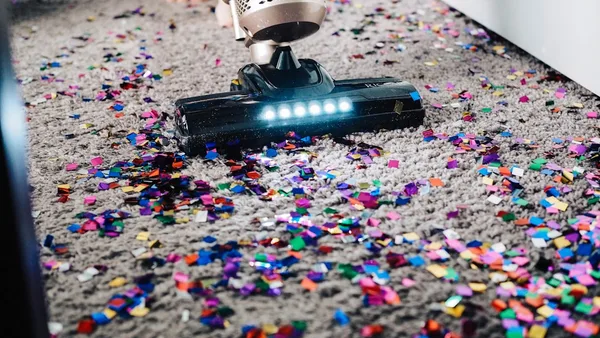 a person using a vacuum to clean a carpet