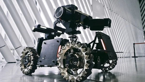 A black and white photo of a camera on wheels